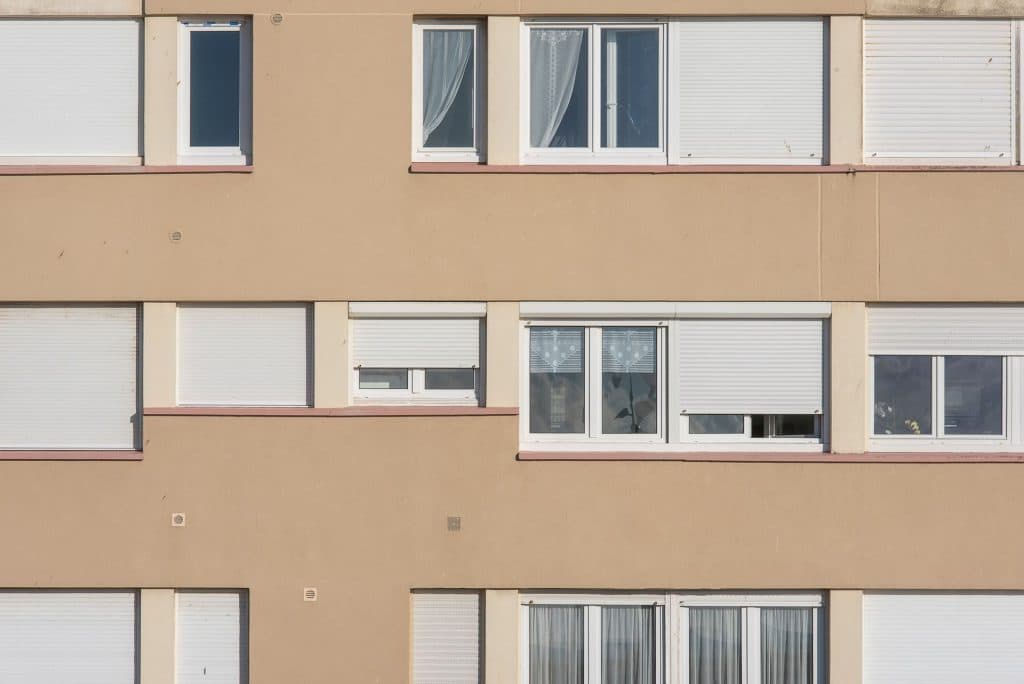 Termoizolacija fasada Bež fasada stambene zgrade sa roletnama na prozorima