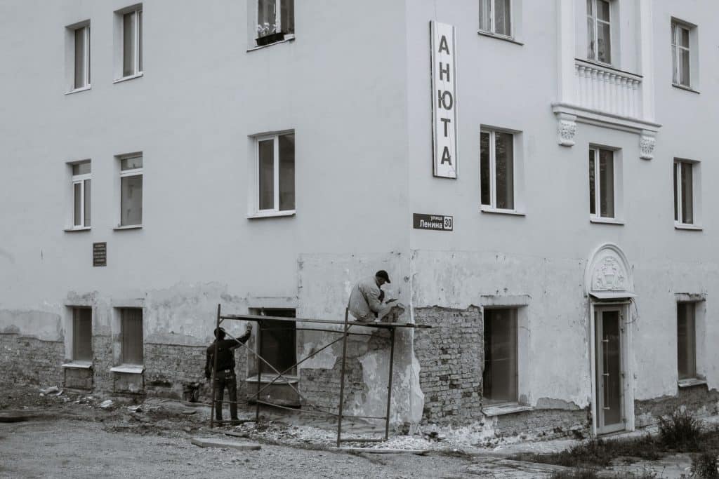 Fasaderski radovi Radnici popravljaju oštećenu fasadu stambene zgrade